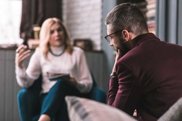 a woman coaches a man through dual diagnosis for depression and addiction